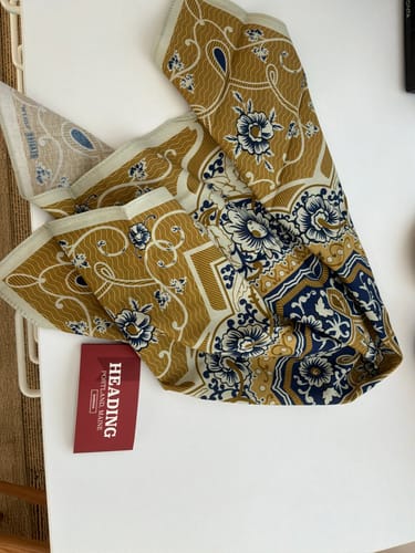 Customer's Fleur D'Or bandana showing the gold and blue filigree pattern with a red brand tag.