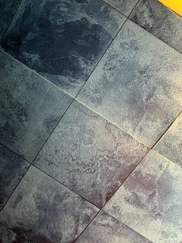 Customer's Bodø blå selvklebende fliser installert på et gulv, viser tydelige skjøter mellom de blå kvadratene.