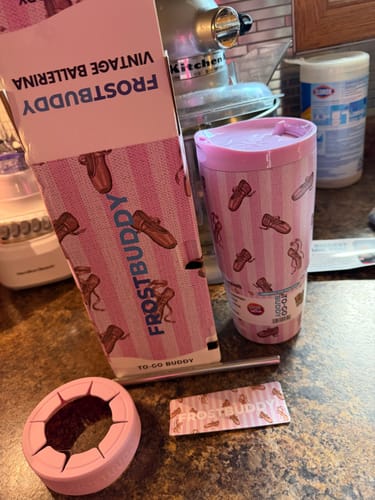 Customer's Vintage Ballerina To-Go Buddy tumbler, its packaging, straw, and lid on a kitchen counter.
