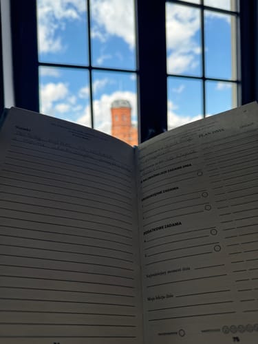 Customer's open planner on a table in front of a window, showcasing its organized, lined pages.