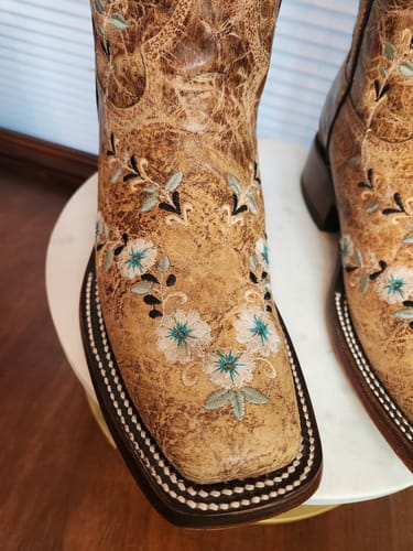 Customer's distressed floral embroidery Western boots, focusing on the square-toe front and detailed stitching.