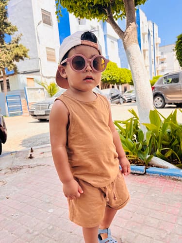 Customer's child wearing brown Nenina & Co Gafas de sol Scottish Cat eyes outdoors with a cap.