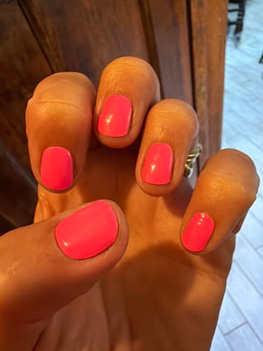 Customer's hand showing neon pink nails applied with the Holy Gels Starter Kit.