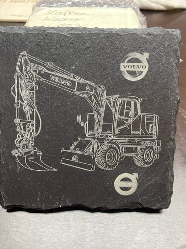 Customer's AtomStack P1 Laser Engraver project, a detailed excavator design etched onto a square piece of slate.