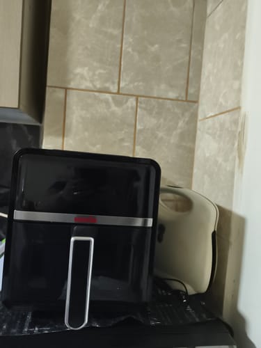 Customer's black Novio StonePro air fryer placed on a kitchen counter next to another small appliance.
