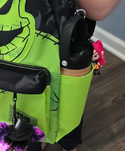 Customer's Bottle Buddy water bottle stored in the side pocket of a bright green backpack.