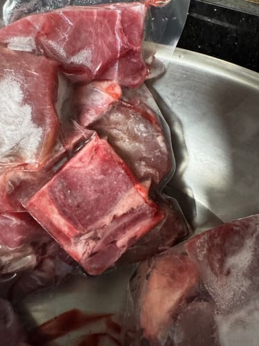 Customer's vacuum-sealed Halal Veal Cubes Bone-In in a metal sink.