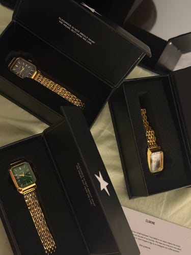 Customer's three Claire De Mains watches in open black display boxes on a surface
