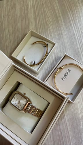 Customer's Isabell Gold watch and matching bracelets displayed in their open gift boxes.