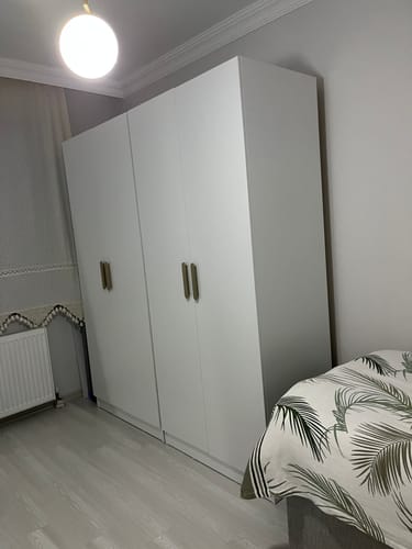 Customer's white Rani BA159 wardrobe installed in a bedroom next to a bed.
