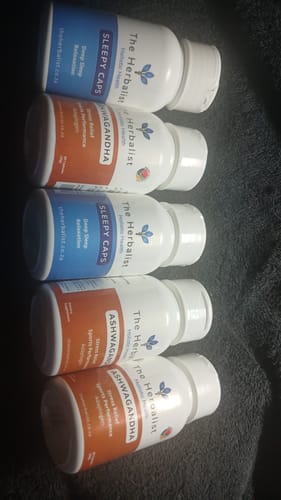 Customer's collection of five white plastic bottles, including Ashwagandha and Sleepy Caps supplements.