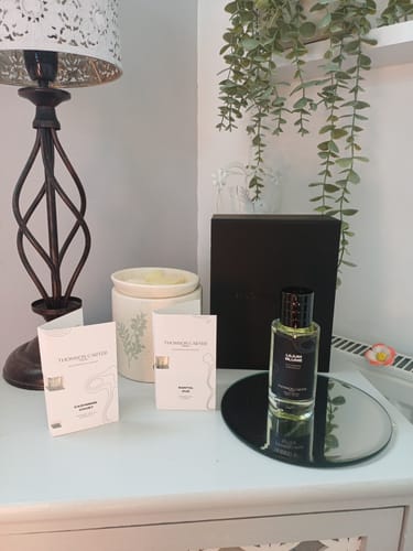 Customer's Lilium Blume Eau de Parfum bottle standing on a mirror, with marketing inserts and a lamp on a table.
