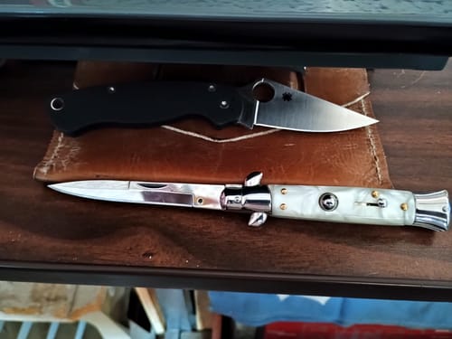 Customer's Italian Style Push Button Switchblade with a white marble handle resting on a leather pad.