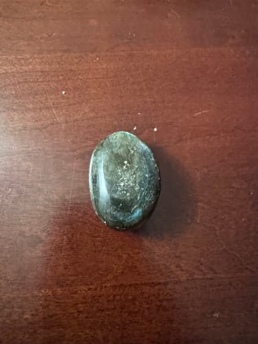 Customer's VIP Crystal Club labradorite moonstone, a smooth, smoky gray oval stone with a subtle blue flash.