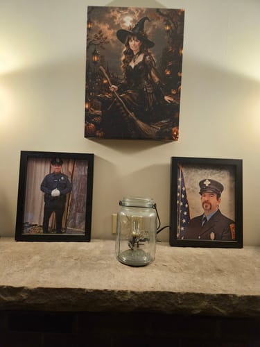 Reviewer's Autumn Witch canvas portrait hanging over a fireplace, displayed with framed photos.