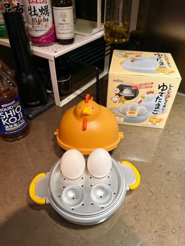 客戶的Akebono母雞造型微波爐煮蛋器，展示打開的容器、內部的蒸盤和兩顆雞蛋，旁為產品包裝盒。