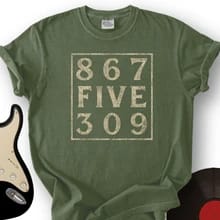Customer's olive green 8675309 T-Shirt with white printed graphic text next to a guitar and vinyl record.