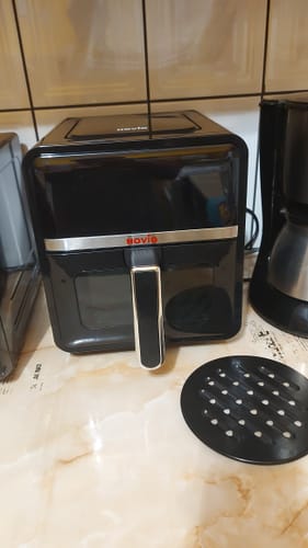 Customer's black Air Fryer Novio StonePro placed on a kitchen counter with the removable grate beside it.