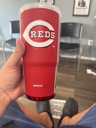 Customer's Mystery To-Go Buddy held by hand, showing red Reds baseball design