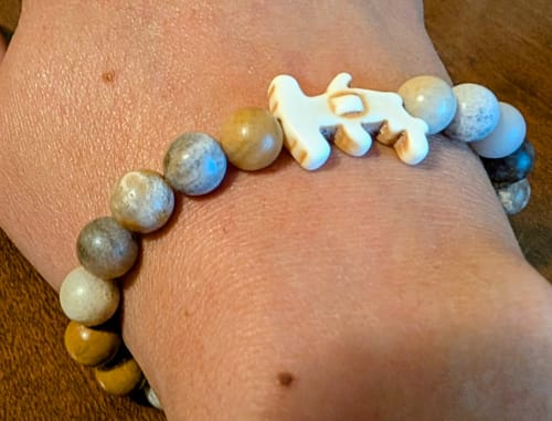 Customer's Shark Week Bracelet with earth-tone beads and a white hammerhead charm worn on a wrist.