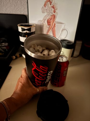 Customer's black Coca-Cola Zero To-Go Buddy cup being held by a hand and filled with ice