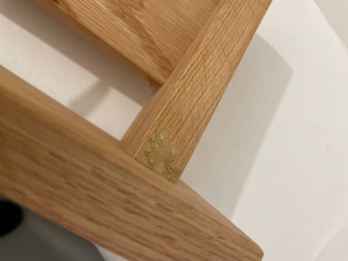 Reviewer's Solid Oak Coat Rack with a visible patch of dried filler material in the wooden corner joint.