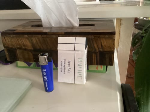 Customer's blue Plain Jane Lighter standing next to a pack of hemp rolls on a table