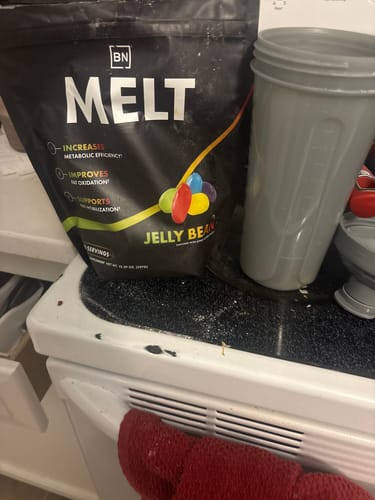 Reviewer's black Melt supplement bag and a grey shaker cup sitting on a white kitchen counter.