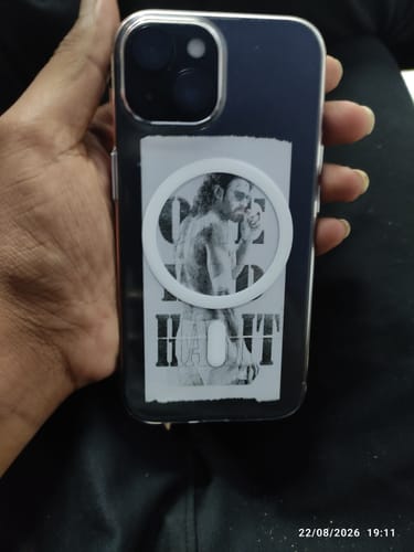 Customer's Anti Yellow MagSafe Clear Case on an iPhone 15, held in a hand with a sticker applied over the magnet.