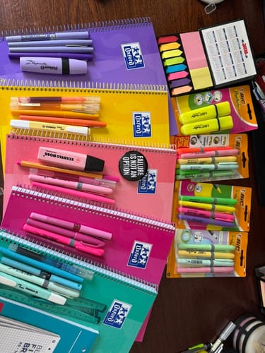 Reviewer's collection of colorful Oxford European Book spiral notebooks laid out with assorted pens and highlighters.