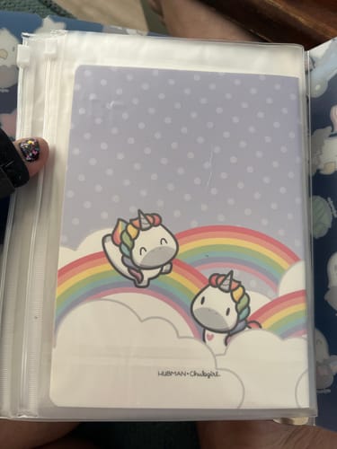 Reviewer's Rainbow Unicorns Sticker Album inside a clear plastic binder sleeve showing cute unicorn and rainbow art.