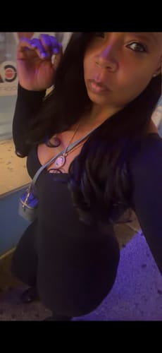 Reviewer wearing a black Naked Tie Closed Toe Jumpsuit with a square neckline, looking at the camera.