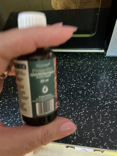 Customer's hand holding a 30 ml bottle of Proactive Grapefruitmag Kivonat Cseppek, close-up.