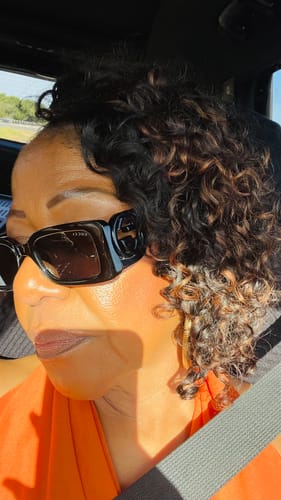Reviewer wearing Spanish Curl Weft Bundles in a natural dark shade, styled in curly, layered hair.