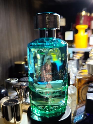 Customer's Jo Milano Full House Refresh bottle in teal glass, surrounded by other perfume bottles on a shelf.