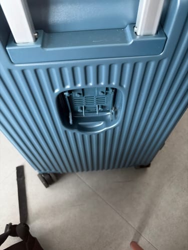 Customer's blue suitcase showing the broken, missing cup holder compartment on the back.