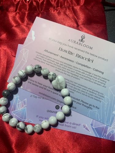 Customer's Howlite Bracelet from VIP Crystal Club, shown with information card on a red fabric background.