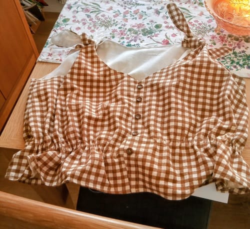 Customer's brown checkered cotton top with tie shoulders and buttons, sewn into a cute garment.