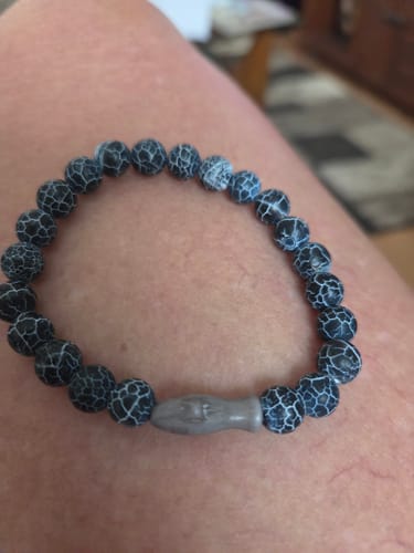 Reviewer's black and white marbled Voyage Bracelet with a grey shark-shaped charm worn on a wrist.