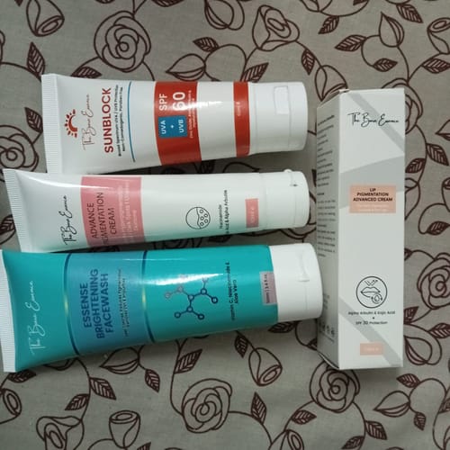 Customer's All Glow Pigmentation Bundle skincare tubes and box laid out on a floral patterned surface.
