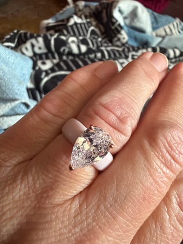 Reviewer's hand wearing a Silicone Ring with a pear-cut stone on a finger, close-up shot.