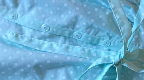 Customer's Prym Snaps Press Fasteners, installed and visible on light blue dotted fabric.