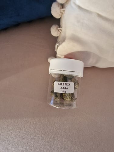Customer's Cali Mix AAA+ plastic jar with label, sitting on a soft surface next to a white pillow.