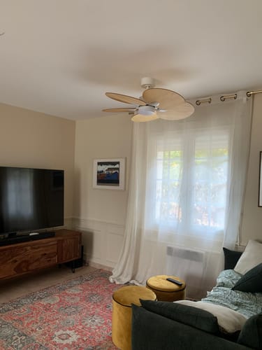 Reviewer's Lotus teinté Chêne ventilateur de plafond installé au milieu d'un salon chaleureux.
