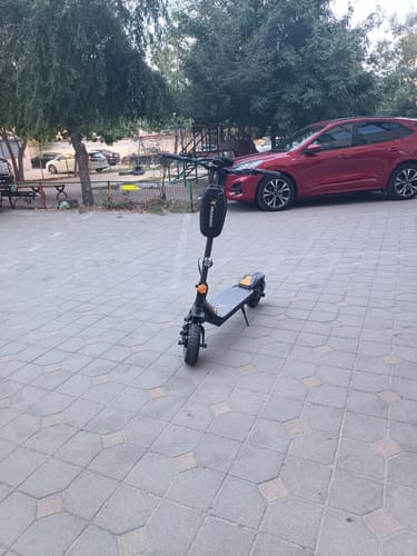 Customer's Ausom Branded Handlebar Bag mounted on a black electric scooter parked in an outdoor lot.