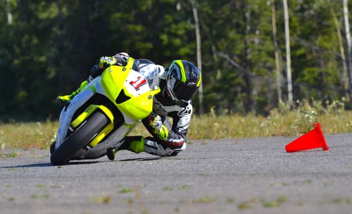 Reviewer's motorcycle rider leaning into a turn on a track with the Alpinestars Supertech R10 Camera Mount attached.