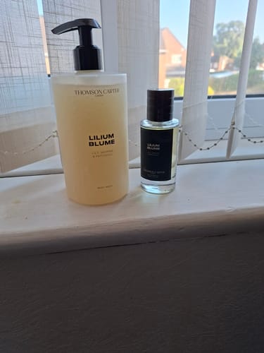 Customer's Lillium Blume body wash bottle and matching fragrance bottle sitting on a windowsill.