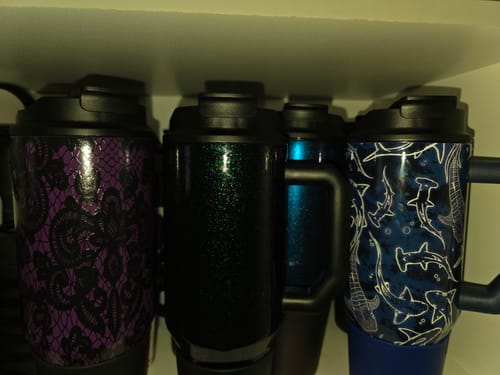 Customer's Thicc Buddy 40oz tumblers with Classic Lids, lined up on a shelf in different patterns.