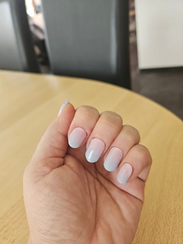 Kundenhand mit aufgetragenen Candy Sorbet UV Gel Nail Wraps, die einen zarten Ombré-Verlauf von Rosa zu Blau zeigen.