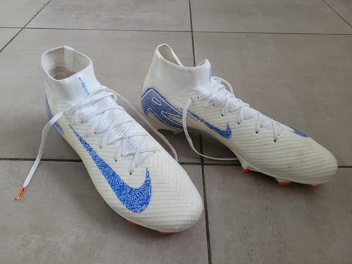 Customer's Mercurial Superfly 10 Elite FG Blueprint chaussures de football blanches et bleues posées au sol.
